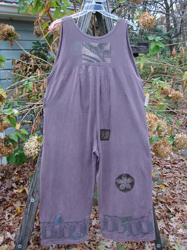 1993 PMU Patched Wide Pant Overall Jumper Travel Dusty Plum Size 1 hanging on a clothesline, showcasing super wide swingy legs, front buttons, and added flower patches, reflecting vintage Blue Fish style.