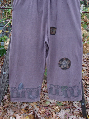 1993 PMU Patched Wide Pant Overall Jumper in Dusty Plum, showcasing wide legs and unique flower patches, features vintage travel-themed designs and three front buttons, epitomizing Bluefishfinder.com's signature vintage style.