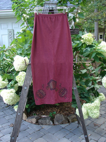 1996 Cotton Lycra Column Skirt River Rock Cayenne Size 1 displayed on a wooden ladder, showcasing its tapered shape and pegged hemline.