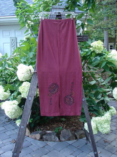 1996 Cotton Lycra Column Skirt River Rock Cayenne Size 1 displayed on a wooden ladder, showcasing its pegged hemline, back kick vent, and tapered shape.