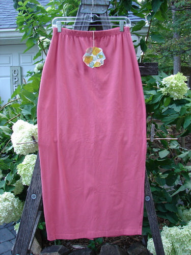 1996 NWT Cotton Lycra Column Skirt Unpainted Oriole Size 2 displayed on a wooden stand, showcasing a full flattened elastic waistline, tapering shape, slimming pegged hemline, and back kick vent.