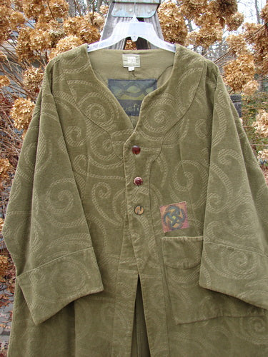 2000 Patched Upholstery Diwmach Coat in Pine, Size 2: A stunning green jacket with a patterned tapestry fabric. Features include colorful patches, vintage buttons, and belled sleeves. Rich in texture and weight.