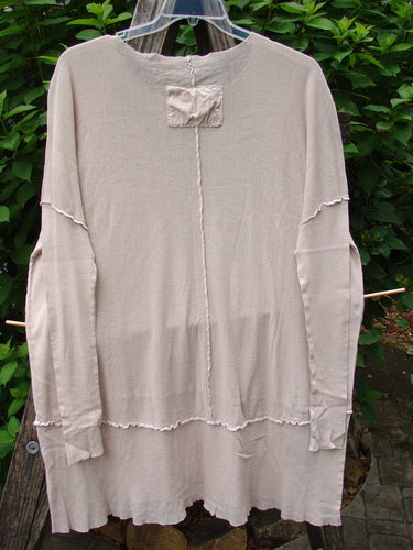 Barclay Cotton Mesh Exterior Stitch Sectional Overtop Unpainted Pink Cloud Size 2 displayed on a clothes rack, featuring super long sleeves, a rounded neckline, and a varying hemline.