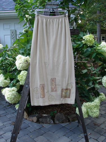 1998 Straight Skirt Airmail Quill Size 0 displayed on a wooden rack, featuring a full elastic waistband and airmail travel theme painted along the hem.