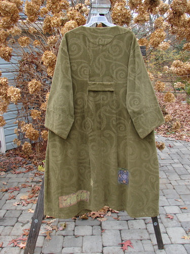 2000 Patched Upholstery Diwmach Coat in Pine, Size 2. Luxurious heavy-weight cotton with damask swirl pattern. Scalloped neckline, vintage buttons, belled sleeves, and pleated rear. Rich texture and weight. Bust 54, waist 54, hips 62. Length: 50 inches in front, graduated in the back. Cuffed and belled sleeves: 28 inches around.