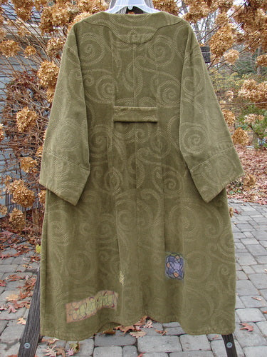 2000 Patched Upholstery Diwmach Coat in Pine, Size 2. Heavy Weight Tapestry Cotton with Damask Swirl Pattern. Scalloped neckline, vintage buttons, belled sleeves. A-line shape, pleated rear, draping fabric. Bust 54, Waist 54, Hips 62. Length: 50 inches in front, graduated in back. Cuffed and belled sleeves: 28 inches.