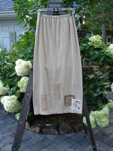 1998 Straight Skirt Airmail Quill Size 0 displayed on a wooden ladder, showcasing its full elastic waistband and airmail travel theme painted around the hem, from Bluefishfinder.com's Winter Resort Collection.