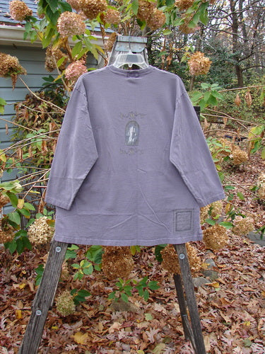 1999 Long Sleeved Tee Candle Blackberry Size 1 displayed on a swinger, showcasing its vintage Blue Fish Clothing style, emphasizing the long sleeves and unique design.