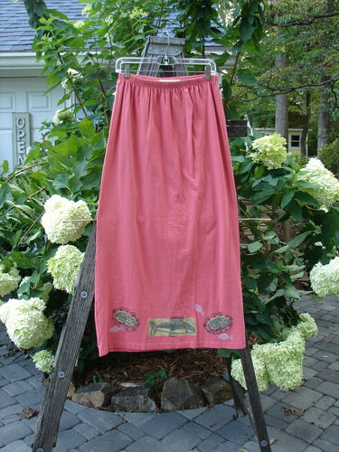 1996 Straight Skirt River Fish Oriole Size 0 displayed on a wooden ladder, showcasing its full elastic waistband and slight A-line lower shape, made from organic cotton.