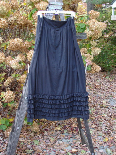 Barclay Voile Foldover Five Ruffle Skirt Unpainted Black Size 2: A dress on a wooden ladder, showcasing a beautiful ruffled five-row paneled hemline and a billowy flare. Perfect for building a special look with suggestive delicate textures.