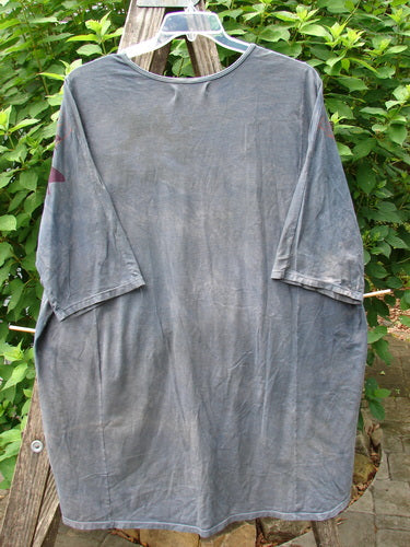 Barclay Tournesol Tunic Gull Flock Mottled Night Sky OSFA, showcasing drop shoulders, loose three-quarter sleeves, and a rounded neckline, hangs elegantly on a clothes rack, highlighting its unique hemline and artistic design.