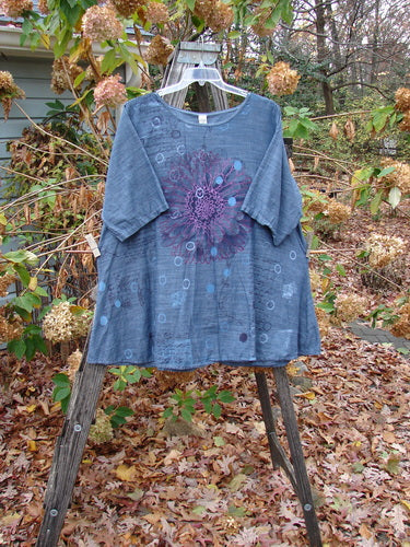 Barclay Woven Short Sleeved Pullover Tunic Mum Cross Dye Navy Size 1, featuring a delicate purple flower design, elegantly displayed on a swinger, showcasing its lightweight cotton fabric and artistic flair.