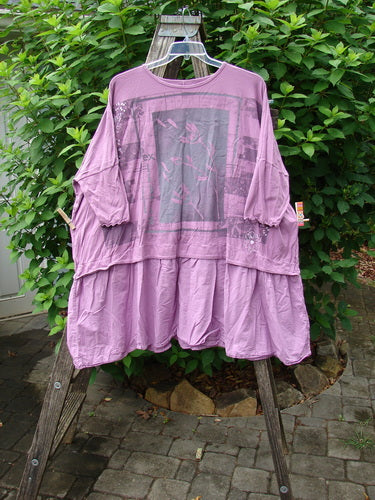 Barclay Batiste Banded Flounce Esperanza Tunic Sprig Crocus OSFA displayed on a rack, showcasing its dolman sleeves, wide boxy shape, rounded neckline, and detailed batiste lower flutter hem.