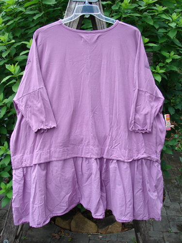 Barclay Batiste Banded Flounce Esperanza Tunic Sprig Crocus OSFA, featuring dolman sleeves with lettuce edges and a varying hem, displayed on a hanger, showcasing its organic cotton texture.