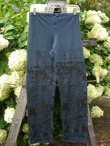 Barclay Cotton Lycra Straight Pant City Plan Lux Silhouette size 0 in dark blue, with a straight-leg cut and black city-map print fading across the lower legs. The cotton-lycra fabric hangs smoothly from a simple waistband, shown clipped upright against leafy white hydrangeas.