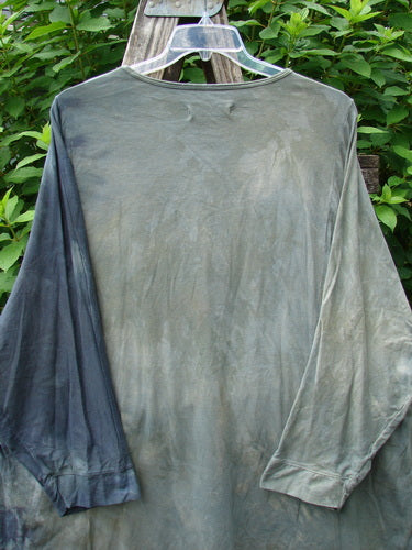 Barclay Art Tee Tree Life Ring Mottled Army Black OSFA displayed on a clothes rack, showcasing its longer tunic length, drop shoulders, loose three-quarter sleeves, and varying hemline.