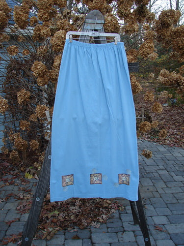 Image alt text: 1997 Elements Dock Straight Duo Shells Atlantis Size 2 blue skirt on a rack, a close-up of a blue sheet, a blue towel on a wooden stand, a close up of a metal object.