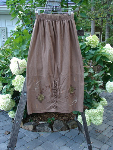 1997 Escapade Skirt Celtic Turn Mandorla Size 1 displayed on a wooden stand, featuring a lace-up design and dynamic Celtic patterns, part of the Blue Fish Holiday Collection in organic cotton.