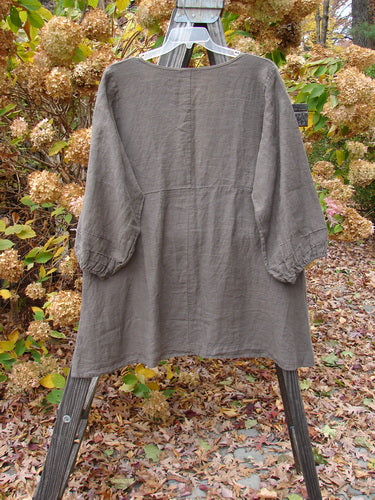 Barclay Linen Deep V Single Button Cardigan on rack, grey shirt on swinger, leaves on ground, wood plank.