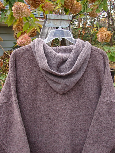 Barclay Fleece Hooded Square Pocket Pullover, featuring a close-up view of its textured fabric and distinctive square pocket design, crafted from heavy weight organic cotton recycled poly, showcased on a hanger.