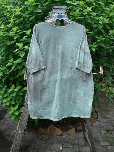 Barclay Tournesol Tunic Spotted Cat Mottled Grass Field OSFA displayed on a rack, showcasing its unique drop shoulders, loose three-quarter sleeves, and a distinctive side garden and tiny village theme.