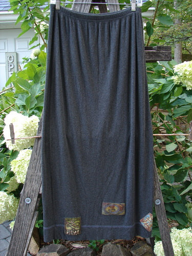 2000 Patched Rayon Lycra Rib Linear Skirt Charcoal Heather Size 1 displayed on a wooden ladder, showcasing its full elastic waistband, slightly flared lower shape, exterior horizontal hem stitchery, and superior drape.