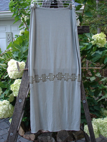 2000 Rayon Lycra Narrow Skirt Celtic Celebration Ash Size 2 draped on a wooden ladder, featuring horizontal panels and a full elastic waistband.