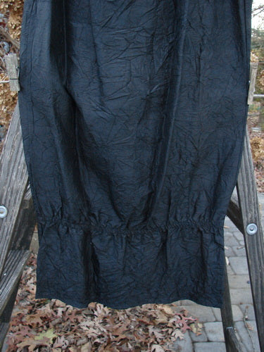 2000 Signed by Jen Shaunting Silk Gather Duo Spin Size 1: A black skirt on a ladder and a pile of brown leaves on the ground.