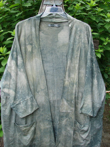 Barclay Bamboo Dolman Day Jacket in Mottled Field Grass displayed on a hanger, showcasing open front, two drop pockets, cuffed sleeves, and unique hemline, embodying BlueFishFinder's vintage, expressive style.