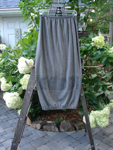 2000 Rayon Lycra Promenade Skirt Celtic Stripe Cliffshadow Size 0, displayed draped over a wooden ladder, highlighting its elastic waistband and light, bouncy fabric with distinctive horizontal accent seams.