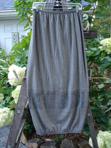 2000 Rayon Lycra Promenade Skirt Celtic Stripe Cliffshadow Size 0 displayed on a wooden ladder, showcasing its horizontal accent seams and elastic gathered hem. The full elastic waistband and light fabric create a bouncy, slimming effect.