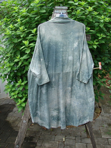 Barclay Bamboo Dolman Day Jacket in Mottled Field Grass, featuring long dolman sleeves, open front, and two drop pockets, draped casually on a wooden post, embodying Bluefishfinder.com's vintage-inspired ethos.