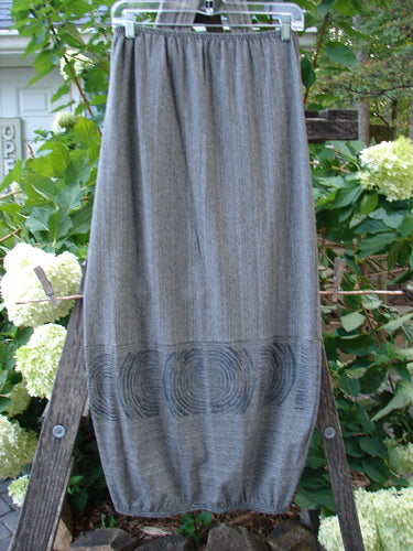 2000 Rayon Lycra Promenade Skirt Celtic Stripe Cliffshadow Size 0 draped on a wooden ladder, showcasing its full elastic waistband, bouncy light fabric, and horizontal accent seams.