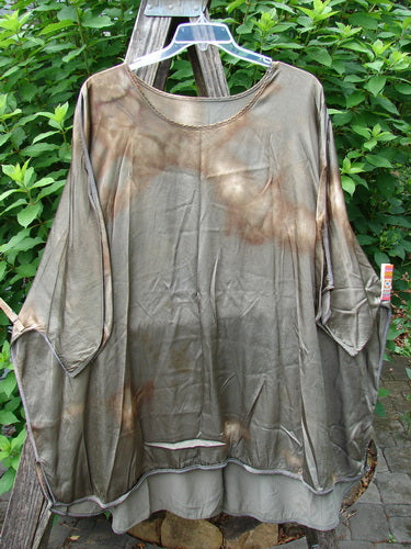 Barclay Viscose Vitreous High Low Tunic Botanicals Mottled Copper Bronze OSFA displayed outdoors on a clothes rack, showcasing its rounded neckline, varying hem, and three-quarter dolman sleeves.