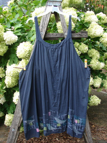 Barclay Batiste Banded Collar Slip Dress Birdy Border Black Size 2, a navy-black sleeveless slip dress with a gathered neckline and wide straps, hanging from a wooden ladder outdoors. The hem shows a subtle Birdy Border print in muted plaid-like tones.