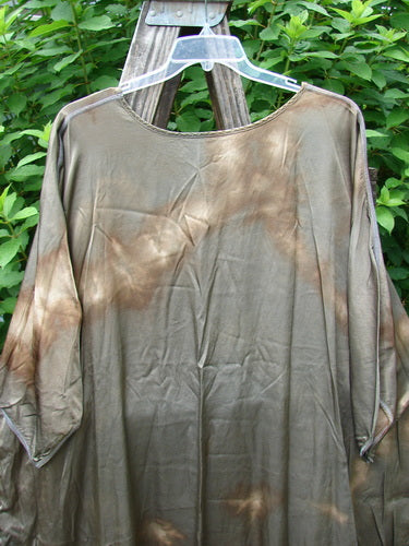 Barclay Viscose Vitreous High Low Tunic in Mottled Copper Bronze displayed outdoors on a hanger, showcasing its rounded neckline, three-quarter dolman sleeves, and varying hem with vented sides.