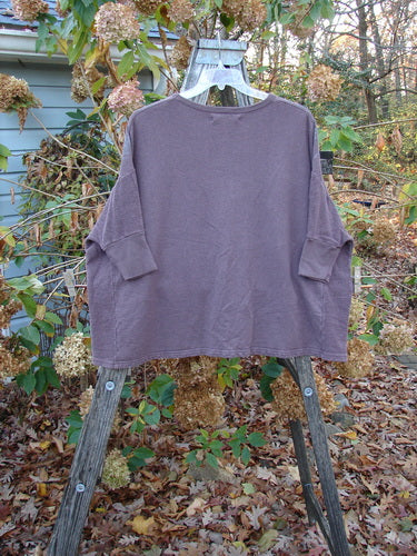 Barclay Hemp Cotton Banded Sleeve Dolman Top Butterfly Maroon OSFA displayed on an outdoor swing, showcasing long sleeves and relaxed fit, embodying BlueFishFinder's vintage, creative style.