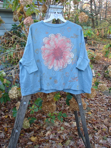 Barclay Hemp Cotton Banded Sleeve Dolman Top Mum Blue Dusk OSFA displayed on a swinger, featuring a prominent pink flower pattern, embodying the vintage and creative spirit of Blue Fish Clothing.