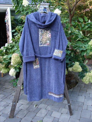 1995 Patched Hooded Chenille Spa Robe Study Mediterranean Size 3 displayed on a wooden stand, showcasing its double-layered hood, cuffed sleeves, oversized pockets, and signature blue fish patch.