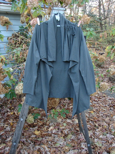 Barclay Cotton Lycra Gather Collar Open Front Jacket Unpainted Forest Size 2 hanging outdoors, showcasing its medium weight and pockets. The jacket embodies Bluefishfinder.com's unique vintage style and creative freedom.