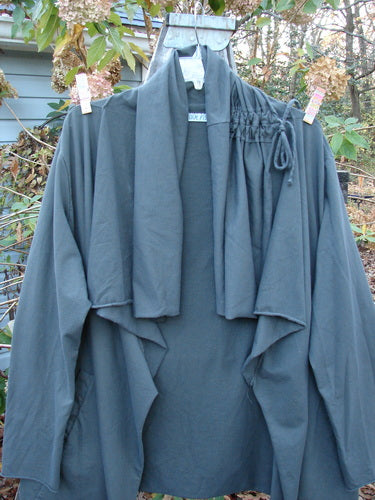 Barclay Cotton Lycra Gather Collar Open Front Jacket Unpainted Forest Size 2 hanging on a clothesline, showcasing its medium weight and pockets, embodying vintage Blue Fish Clothing's unique style.