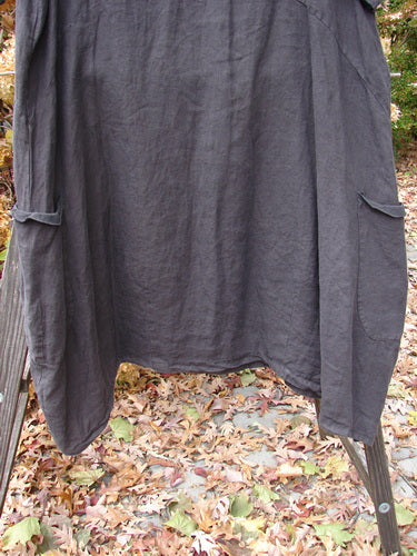 A linen dress with side pockets, V neckline, and empire waist seam.