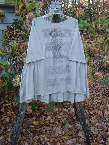 Barclay Three Quarter Sleeve Side Gather Sweep Tunic Bouquet Natural Size 2, displayed on a wooden rack, showcasing its lightweight, pocketless design, ideal for expressing individuality with vintage-inspired style from BlueFishFinder.com.