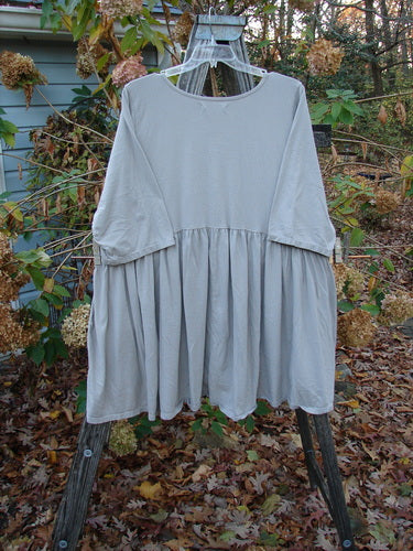 Barclay Three Quarter Sleeve Side Gather Sweep Tunic Bouquet Natural Size 2 displayed on a swing, highlighting its flowing silhouette and lightweight design, reflecting Bluefishfinder.com's vintage Blue Fish Clothing ethos.