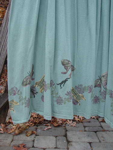 1994 Side Button Jumper Butterfly Garden River Size 1 featuring a rounded neckline, deeper arm openings, and gathered fabric with superior butterfly garden theme paint, displayed on a stone walkway.