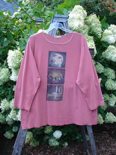 Barclay Long Sleeved Tee Studio Tee Triple Modernist in apricot, size 3, with a soft matte knit and relaxed long sleeves. Three stacked modernist graphic panels run down the chest, while the tee hangs from a wooden ladder against dense green foliage and white blossoms.