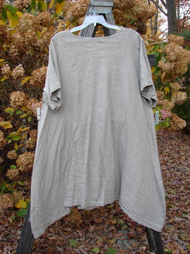 Barclay Linen Figure 8 Drop Pocket Tunic Dress with Hourglass Theme and Varying Hemline on clothes rack.