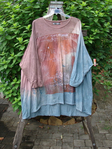 Barclay Art Tee Da Vinci Moon Mottled River OSFA displayed on a fence, showcasing its longer tunic length, drop shoulders, and loose three-quarter sleeves, reflecting Bluefishfinder's vintage, expressive style.