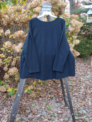 Barclay Cotton Lycra Twinkle Top on swing with wood post and leaves, metal objects.