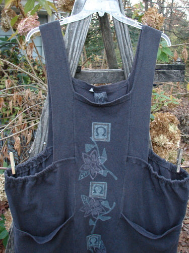 1995 Reprocessed Cottage Jumper Floral Vine Granite Size 3 displayed on a wooden pole, highlighting its thick shoulder straps, sectional bib, and oversized front pockets, showcasing vintage Blue Fish Clothing style.